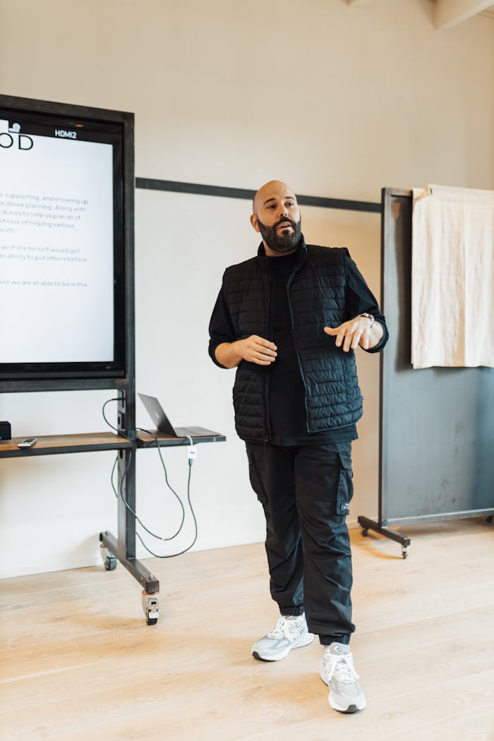 Professional man delivering a presentation in a modern office setting, emphasizing teamwork and leadership.